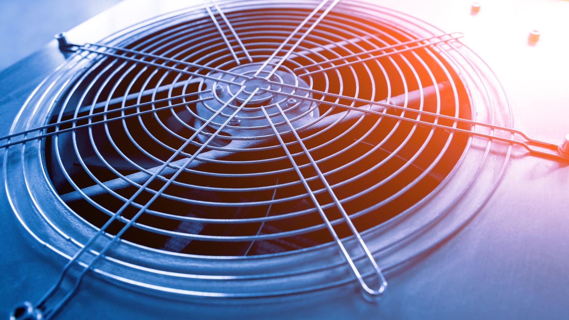 Industrial fan with metal grid and warm orange-blue gradient lighting